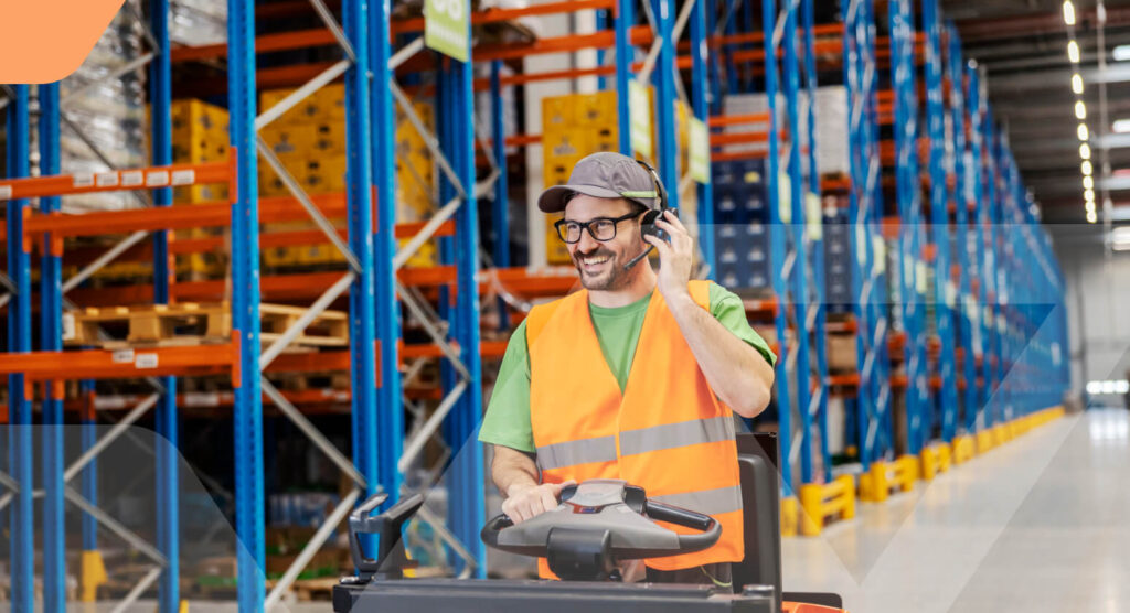 Warehouse employee in safety vest and headset on a pallet truck